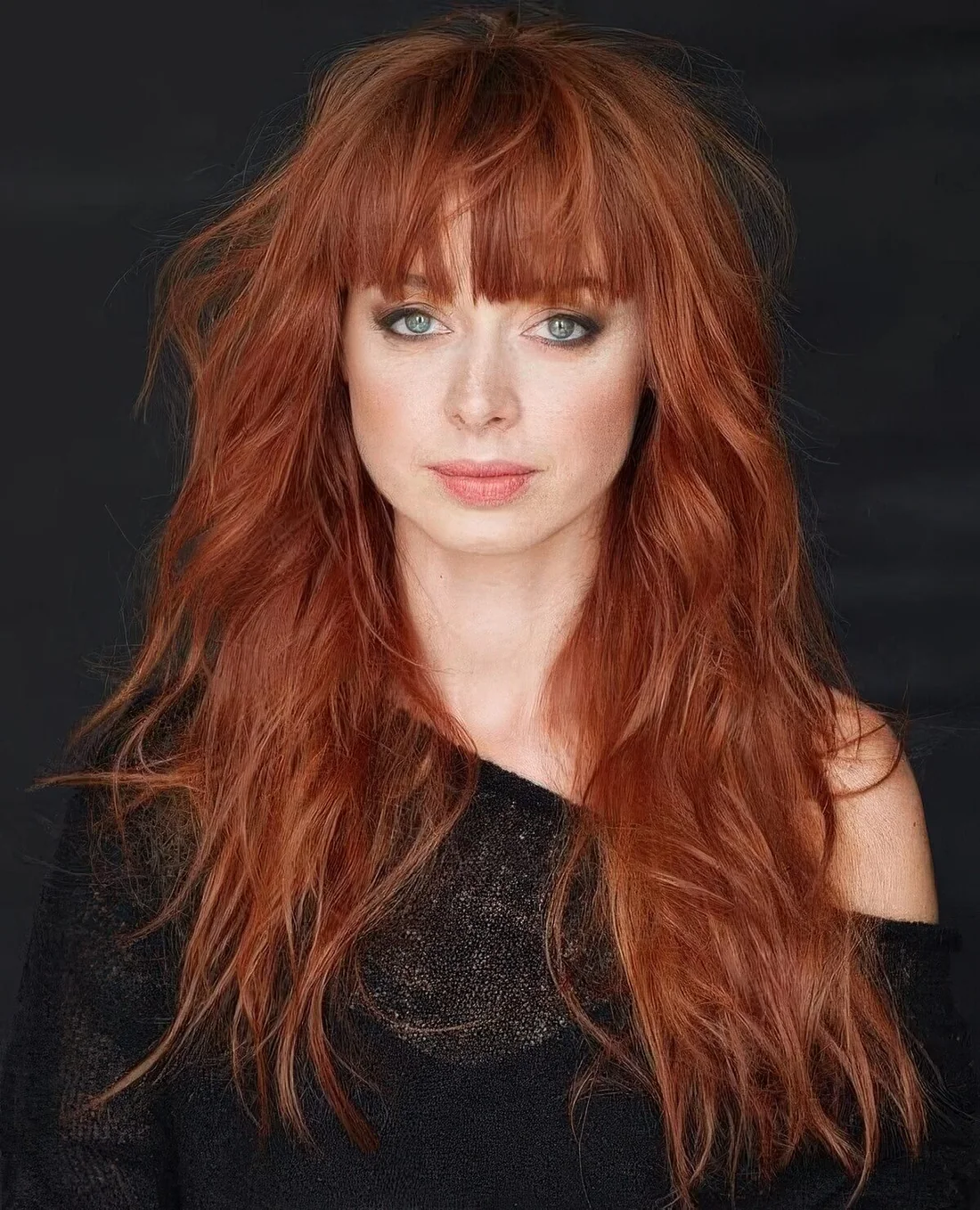 Long layered copper haircut with fringe bangs and a texture to make a statement.