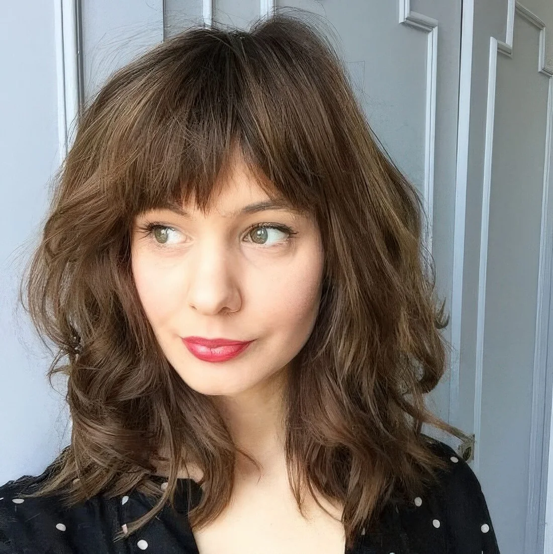 Medium-length haircut with a fringe bang.