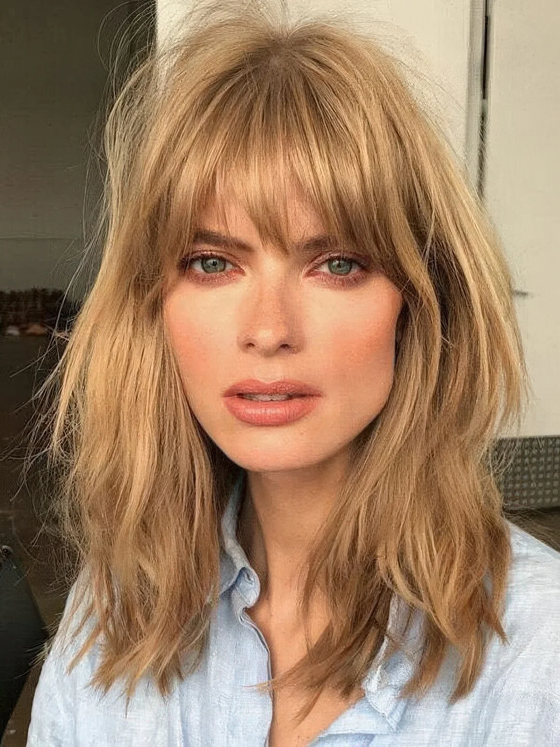 Textured golden blonde hair with outgrown fringe bangs.