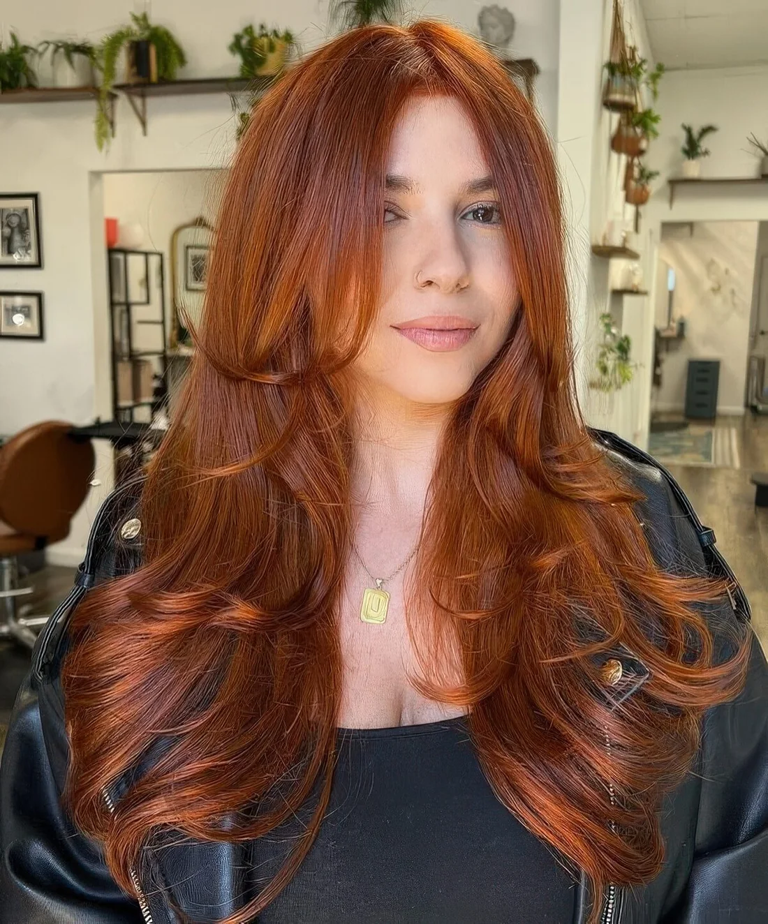 Copper long butterfly haircut with face-framing layers and curled ends.