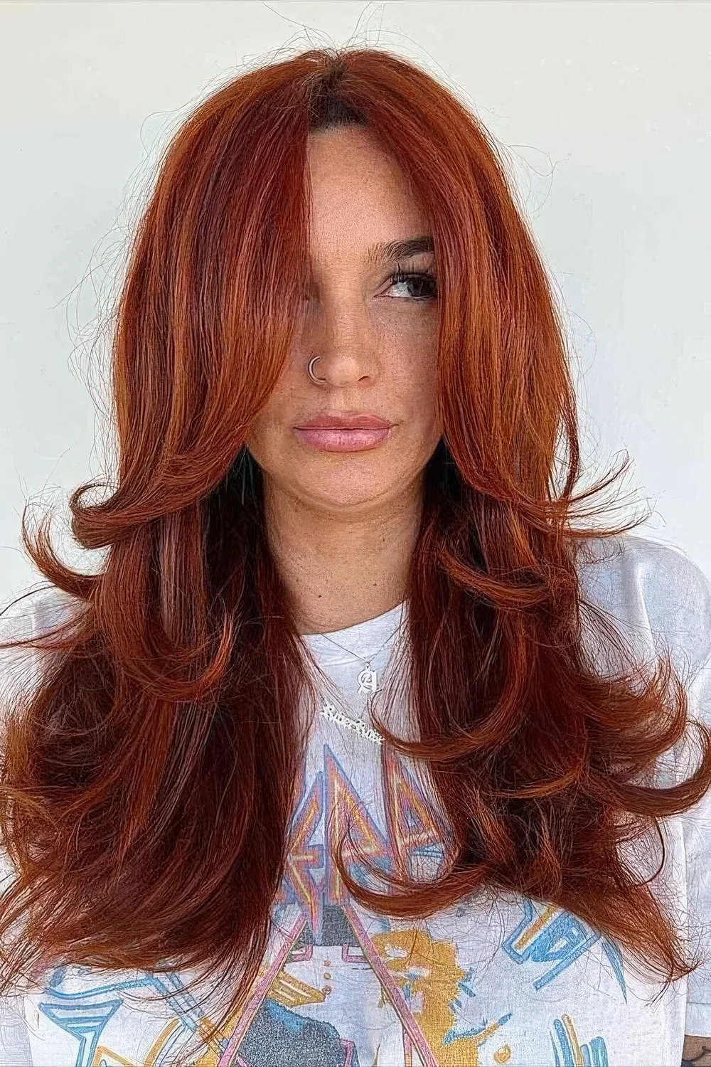 Fab red butterfly haircut on long hair, with a lot of volume, face-framing layers and curled ends.