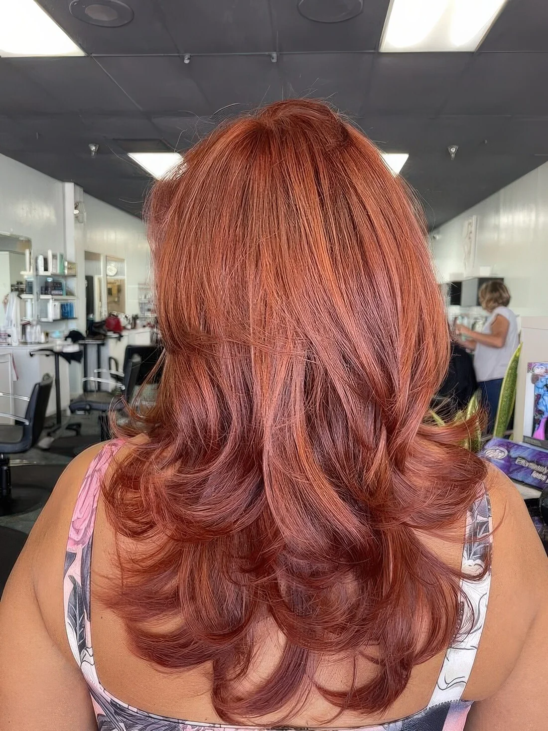 Long red butterfly haircut with a lot of volume and curled ends.