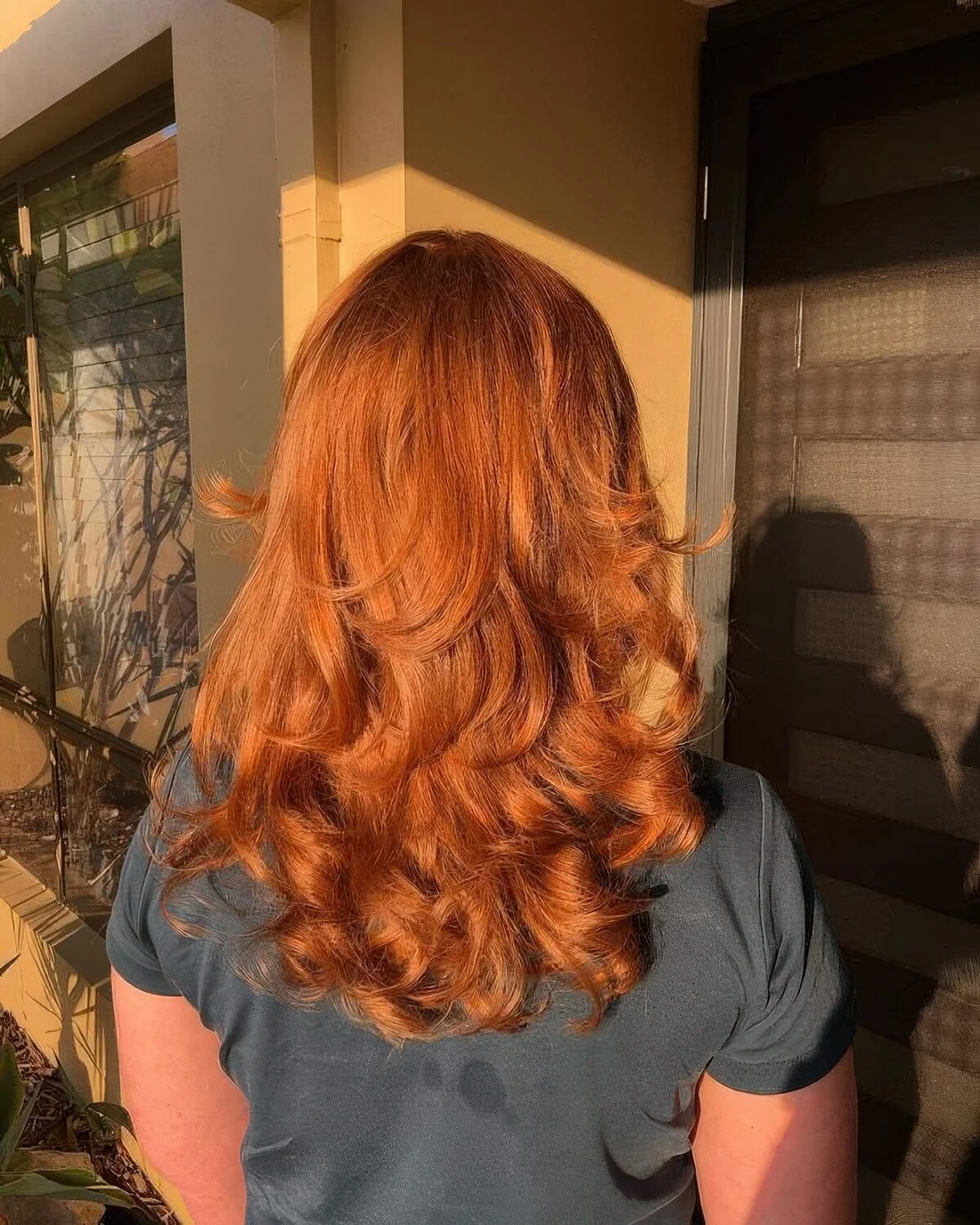 Copper medium haircut with curled ends and a lot of volume.