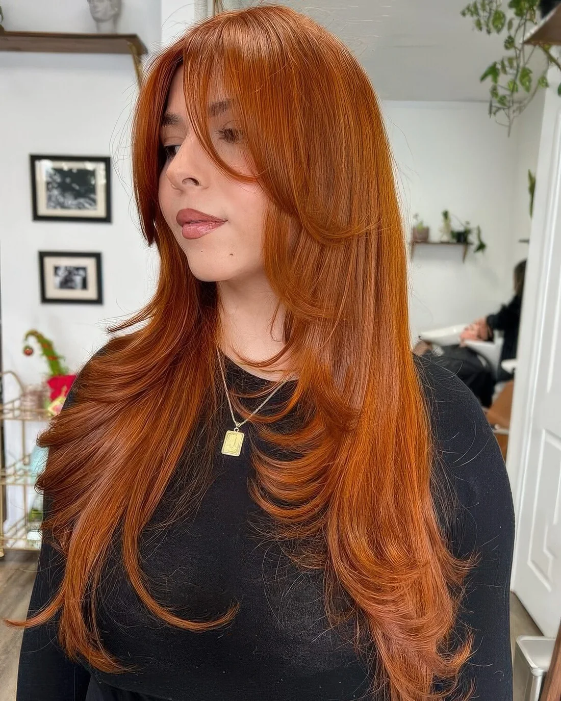 Bright copper long butterfly haircut with face-framing layers and curled ends.