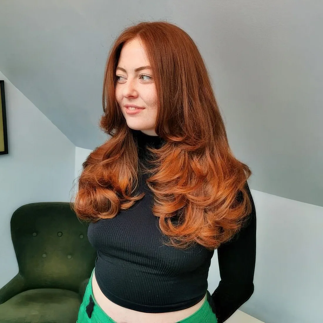 Auburn to copper butterfly haircut with curled ends and a lot of volume.