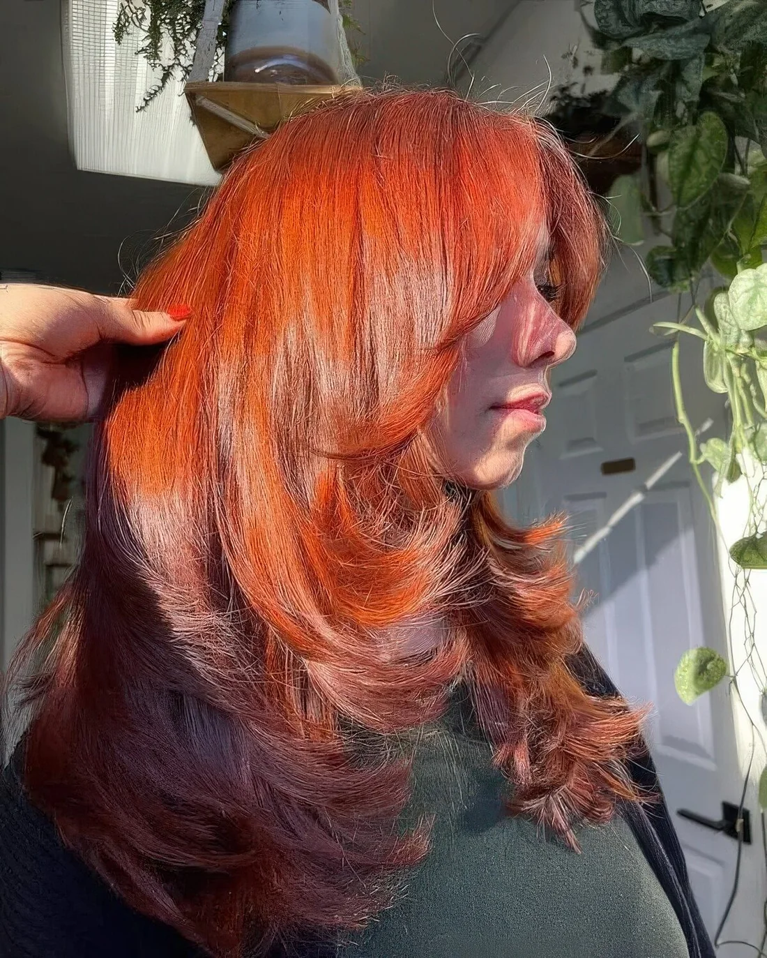 Amazingly bold and catchy red butterfly haircut on long hair, with curled ends and a lot of volume.