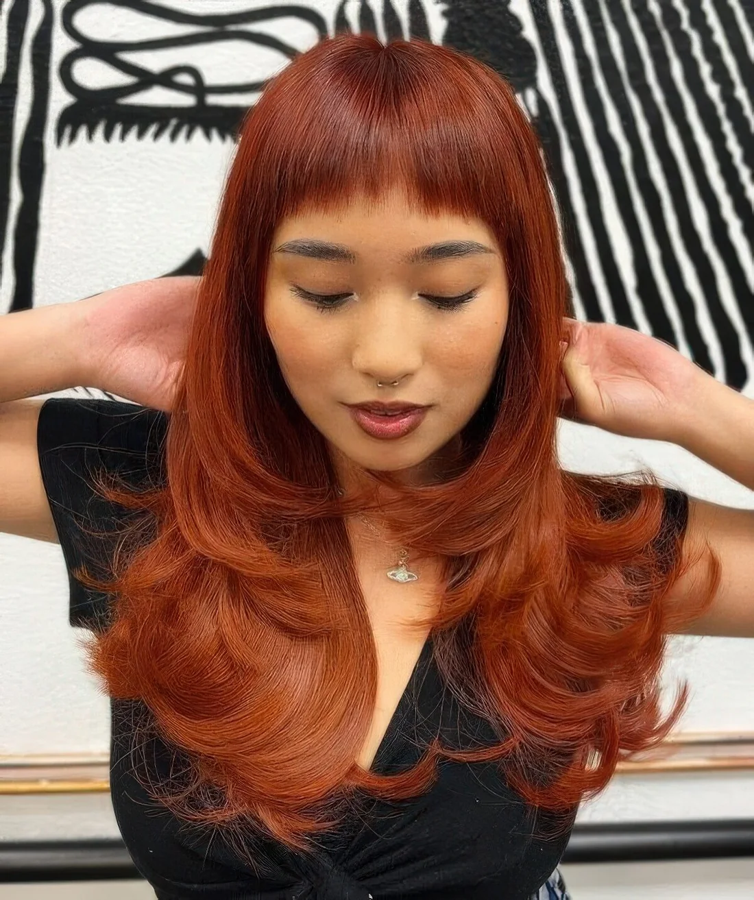 Eye catchy red butterfly haircut on long hair, with baby bangs and curled ends to make a statement.