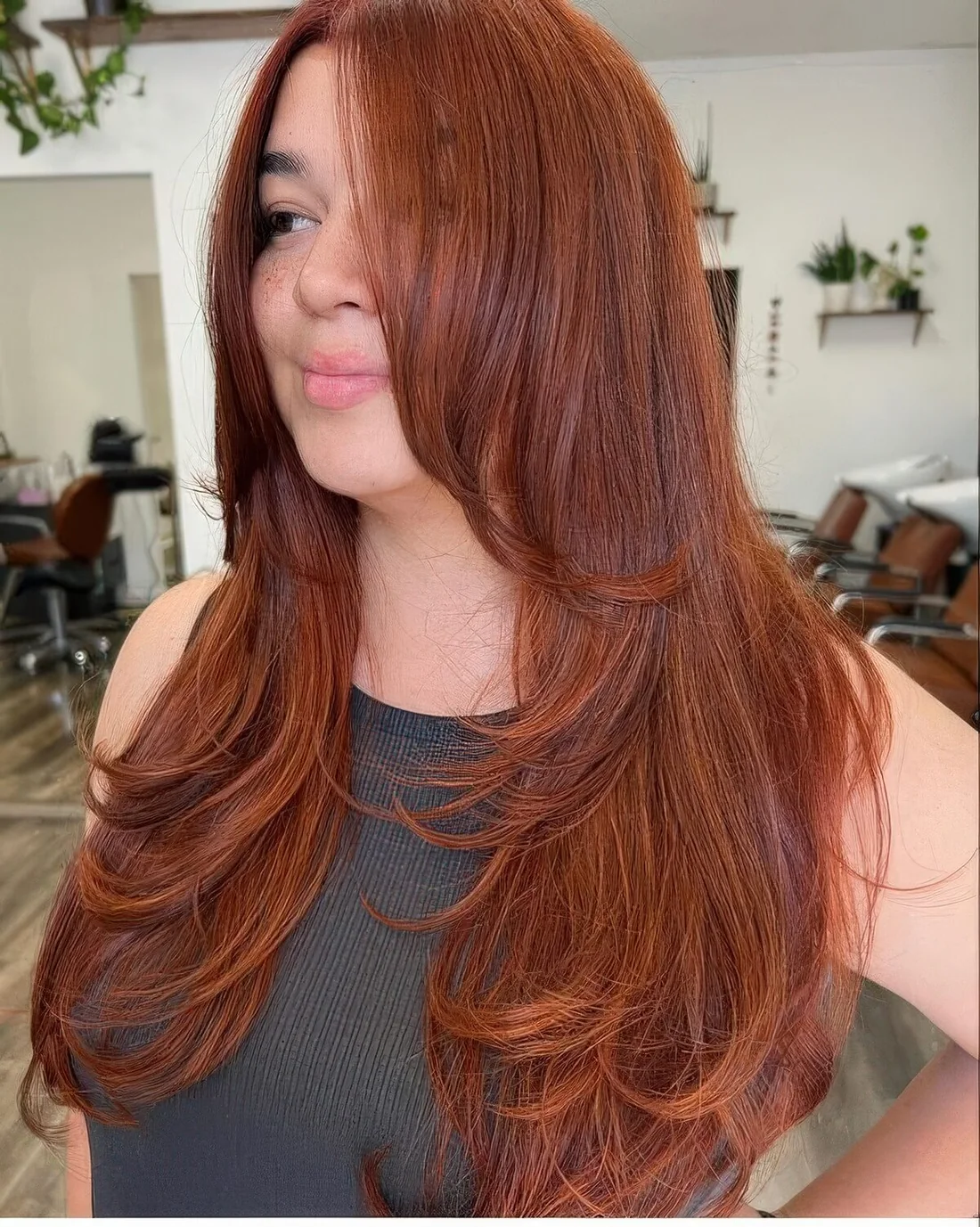 Red butterfly haircut on long hair, with much volume and long curtain bangs.