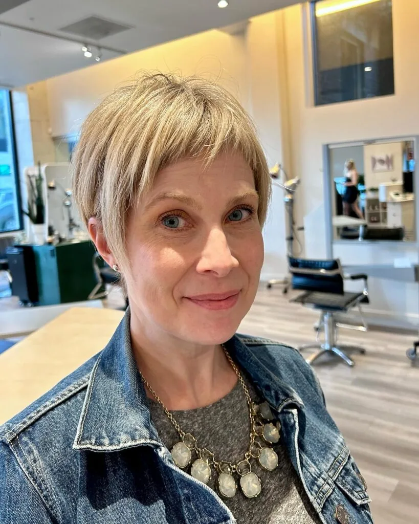ear straight blonde pixie with side swept fringe shown as a haircuts for women over 50 idea