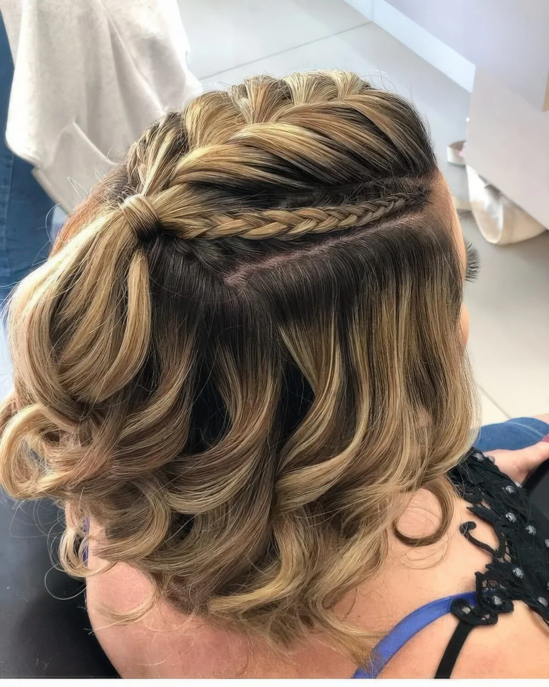Half updo with a large and two small braids on top an waves down.
