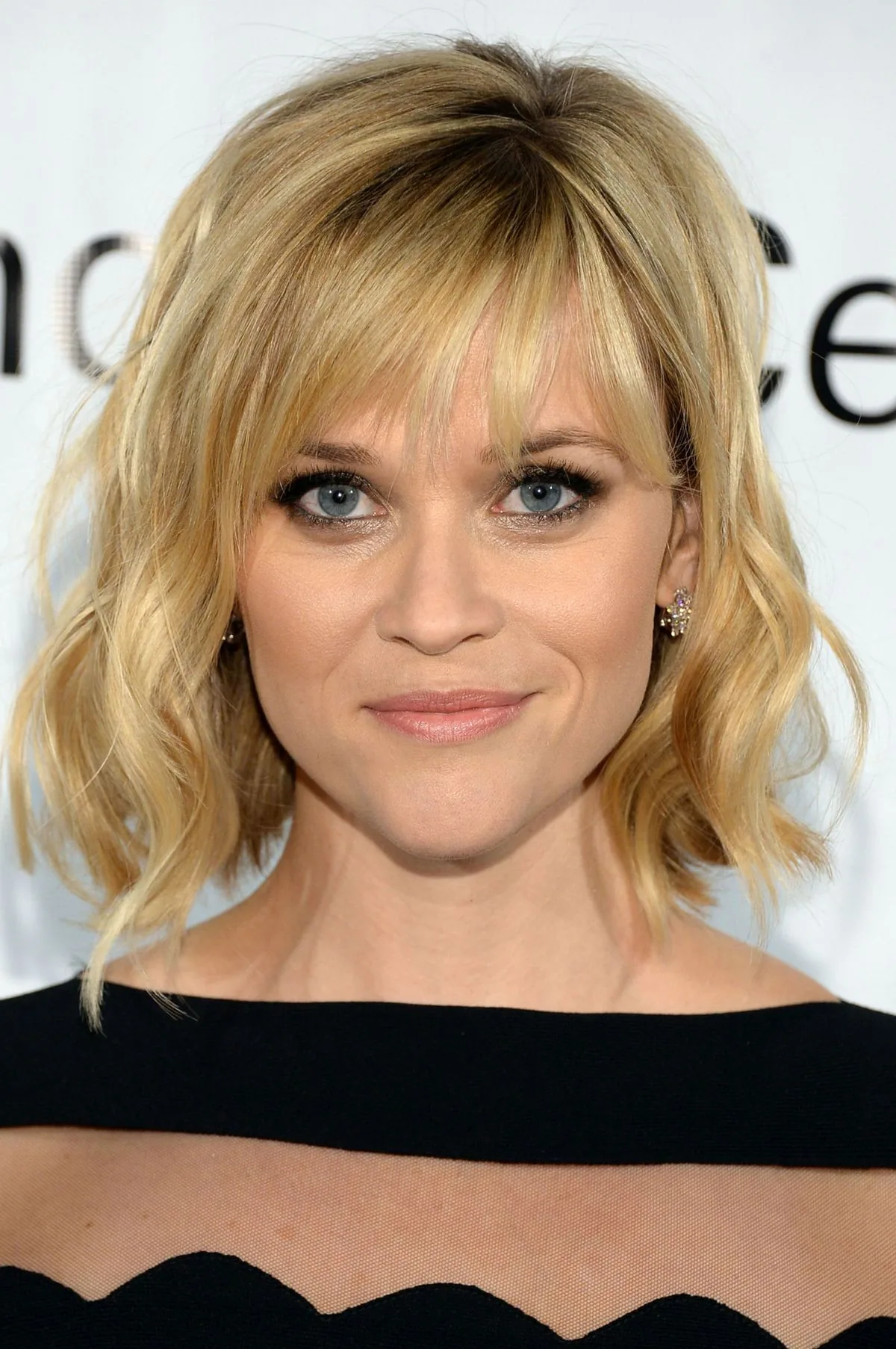 shoulder wavy blonde shag with wispy fringe shown as a hairstyles for women over 40 with bangs idea