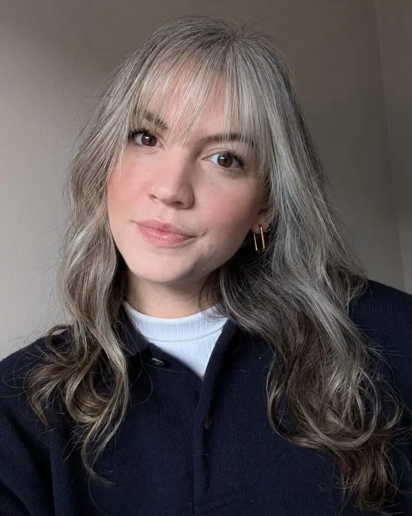shoulder wavy silver layers with curtain fringe shown as a hairstyles for women over 40 with bangs idea