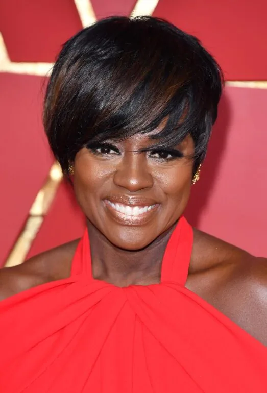 ear straight black pixie with side swept fringe shown as a hairstyles for women over 40 with bangs idea