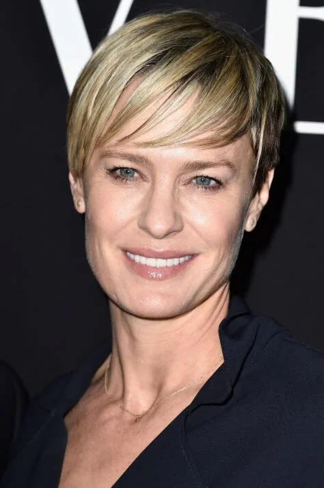 ear straight blonde pixie with side swept fringe shown as a hairstyles for women over 40 with bangs idea