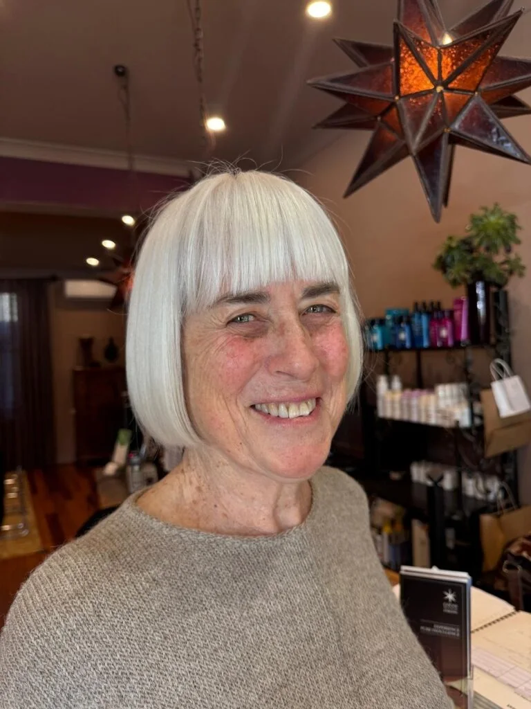 chin straight gray bob with blunt fringe shown as a hairstyles for women over 60 with thin hair idea