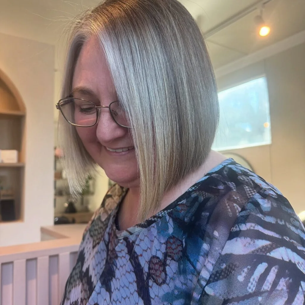 chin straight silver bob shown as a hairstyles for women over 60 idea, featuring straight texture