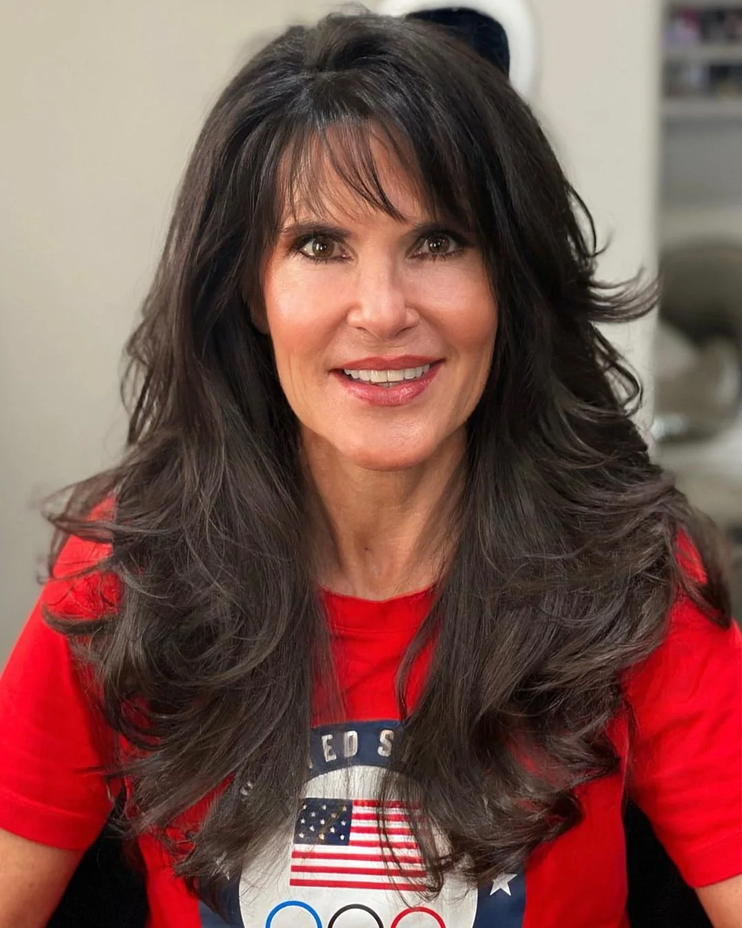 chest wavy brunette layers with curtain fringe shown as a hairstyles with bangs for older women idea