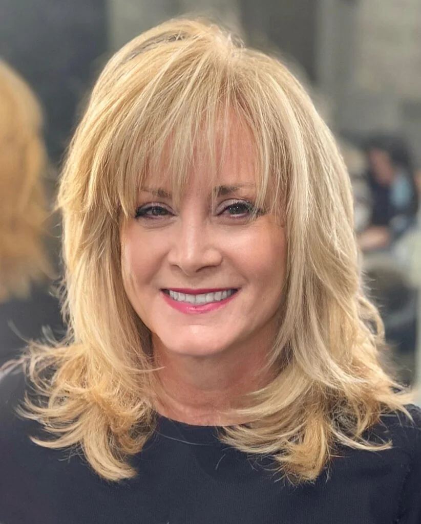 shoulder wavy blonde layers with wispy fringe shown as a hairstyles with bangs for older women idea