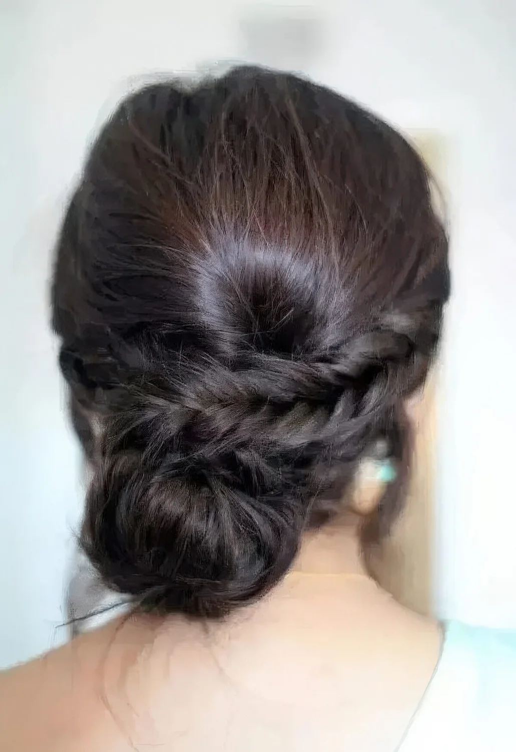 Low bun with a side braid and a bump for a whimsy take on a usual low bun hairstyle.