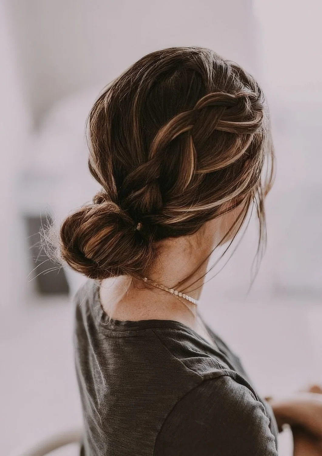 Photo showing low bun with a large sided braid, with the hairstyle clearly visible.