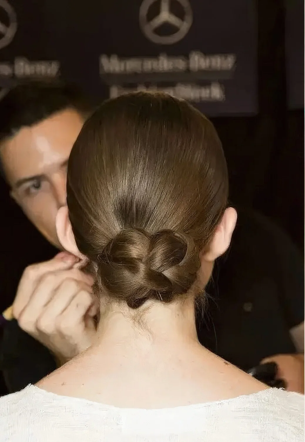 Photo showing sleek low updo with a braided bun, with the hairstyle clearly visible.