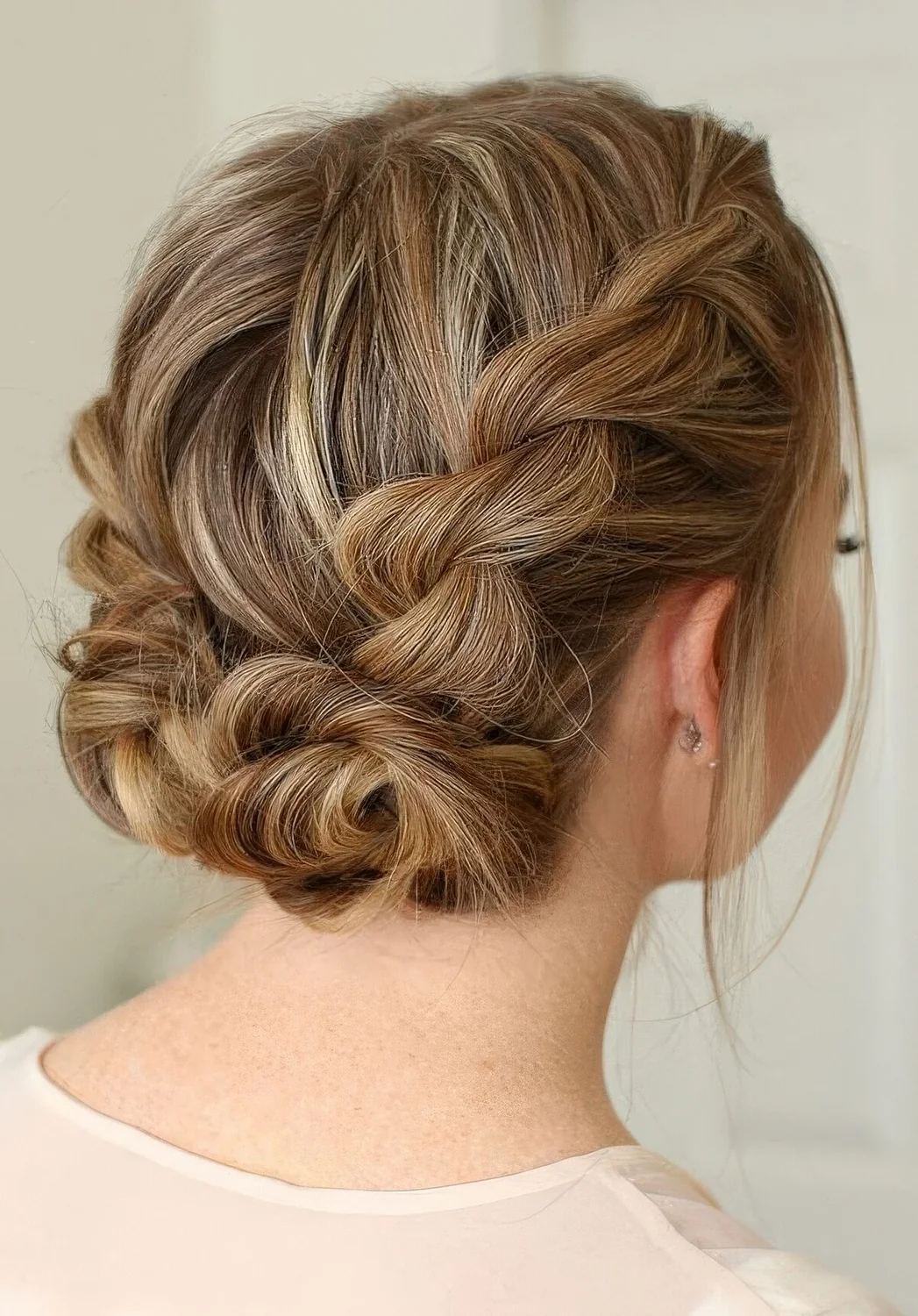 Braided updo with two twisted low buns and volume on top.