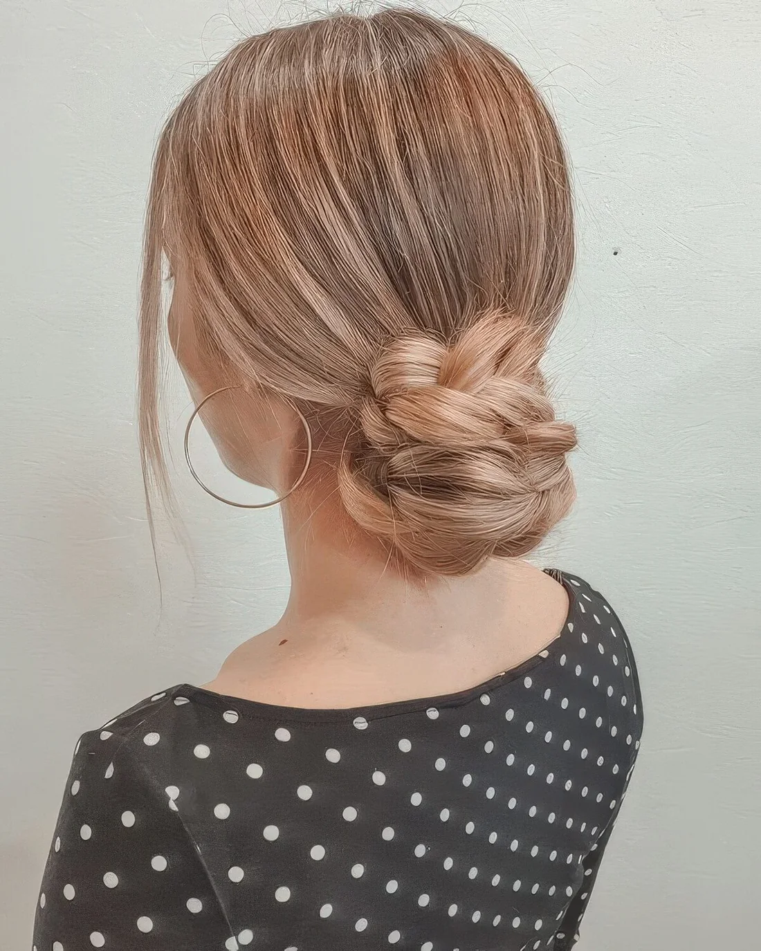 Braided low bun with a sleek top and face-framing hair.