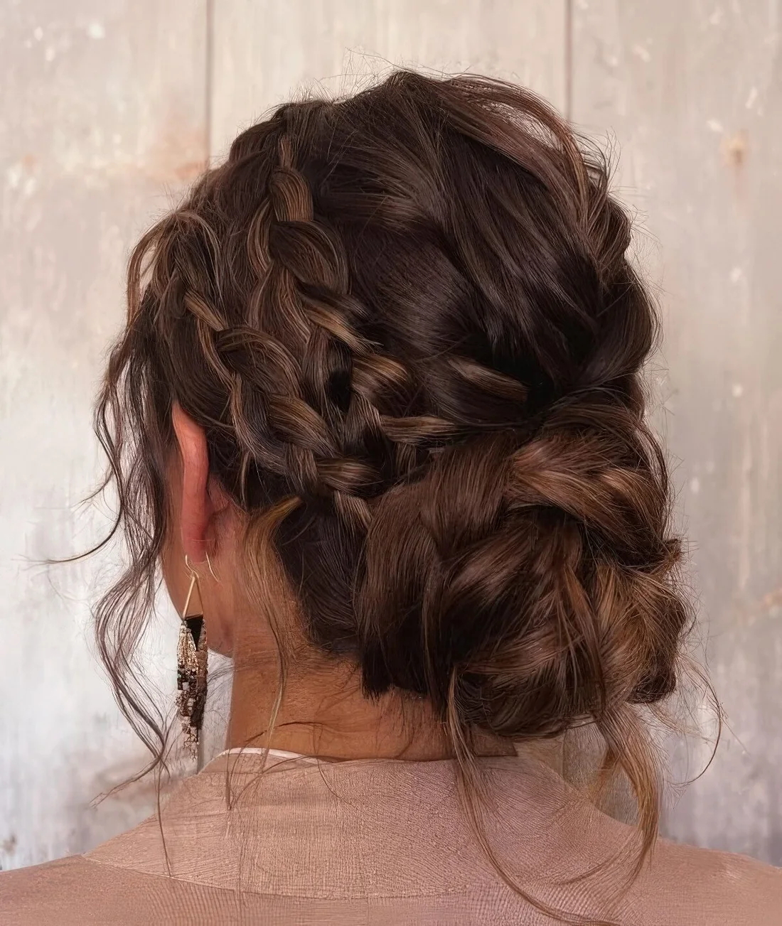 Messy braided low bun with twi side braids and hair down.