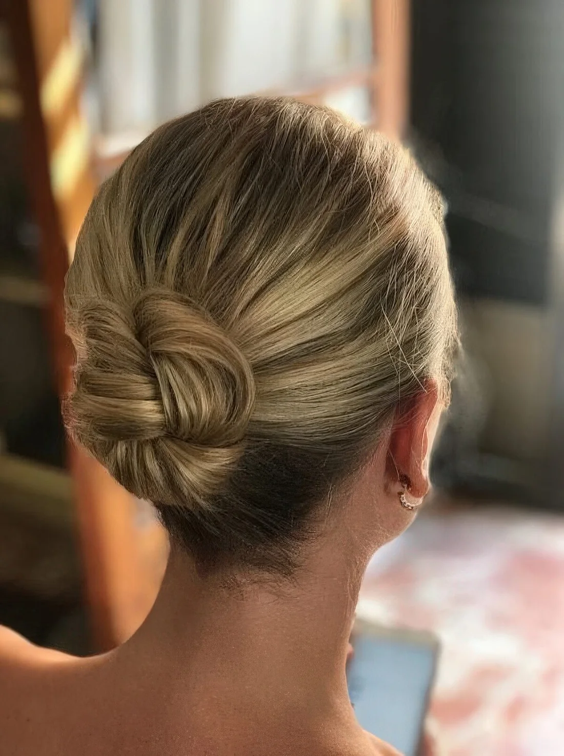 Photo showing braided bun with a volumetric top, with the hairstyle clearly visible.