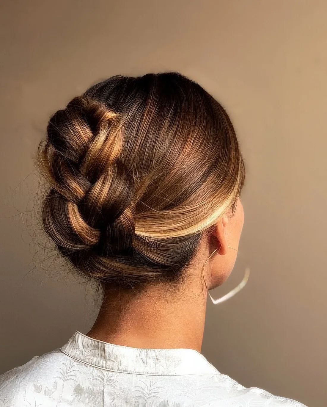 Photo showing braided updo with a sleek top, with the hairstyle clearly visible.