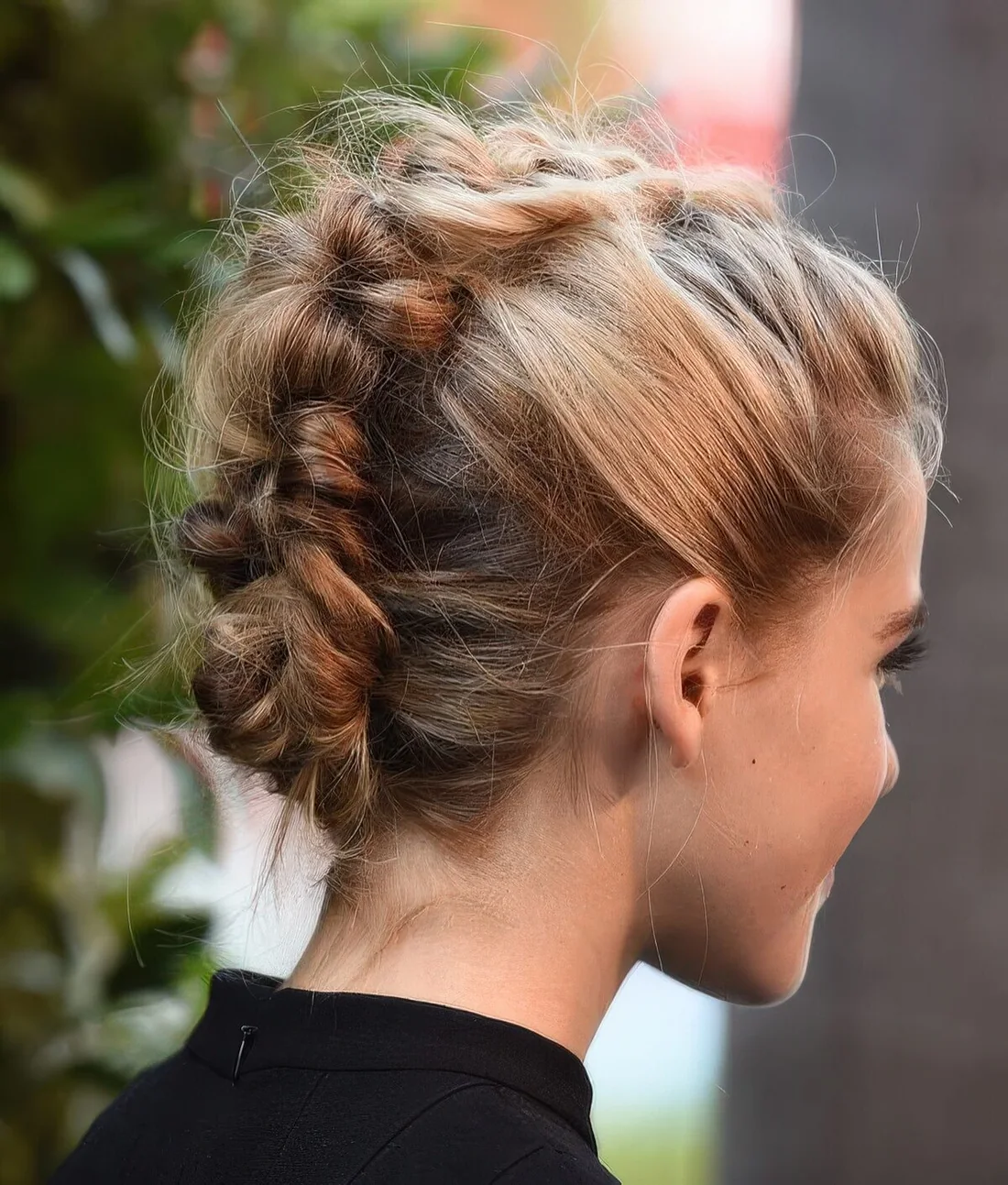 Messy braided updo with a volume on top.