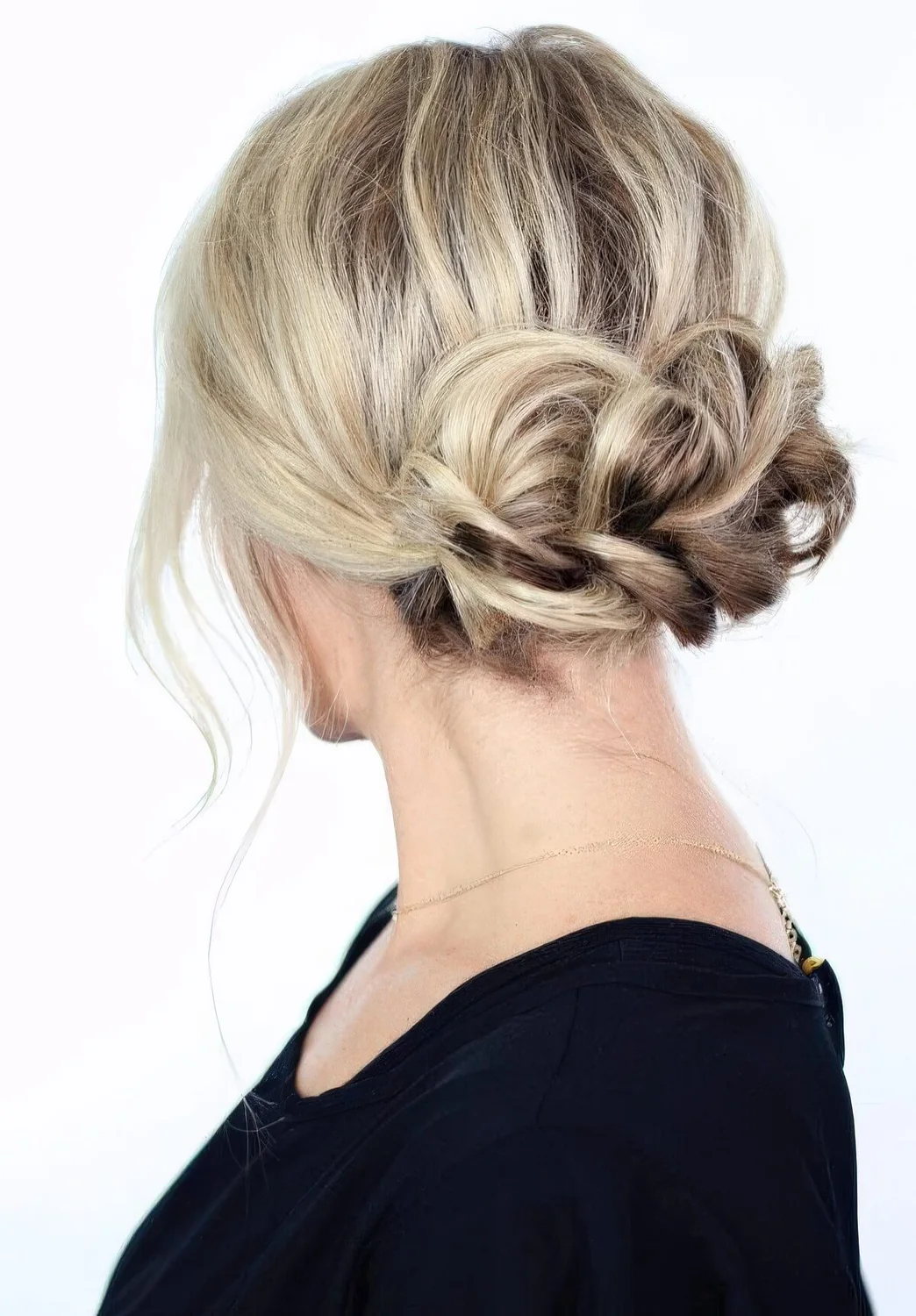 Braided low updo with some volume on top and some locks down.