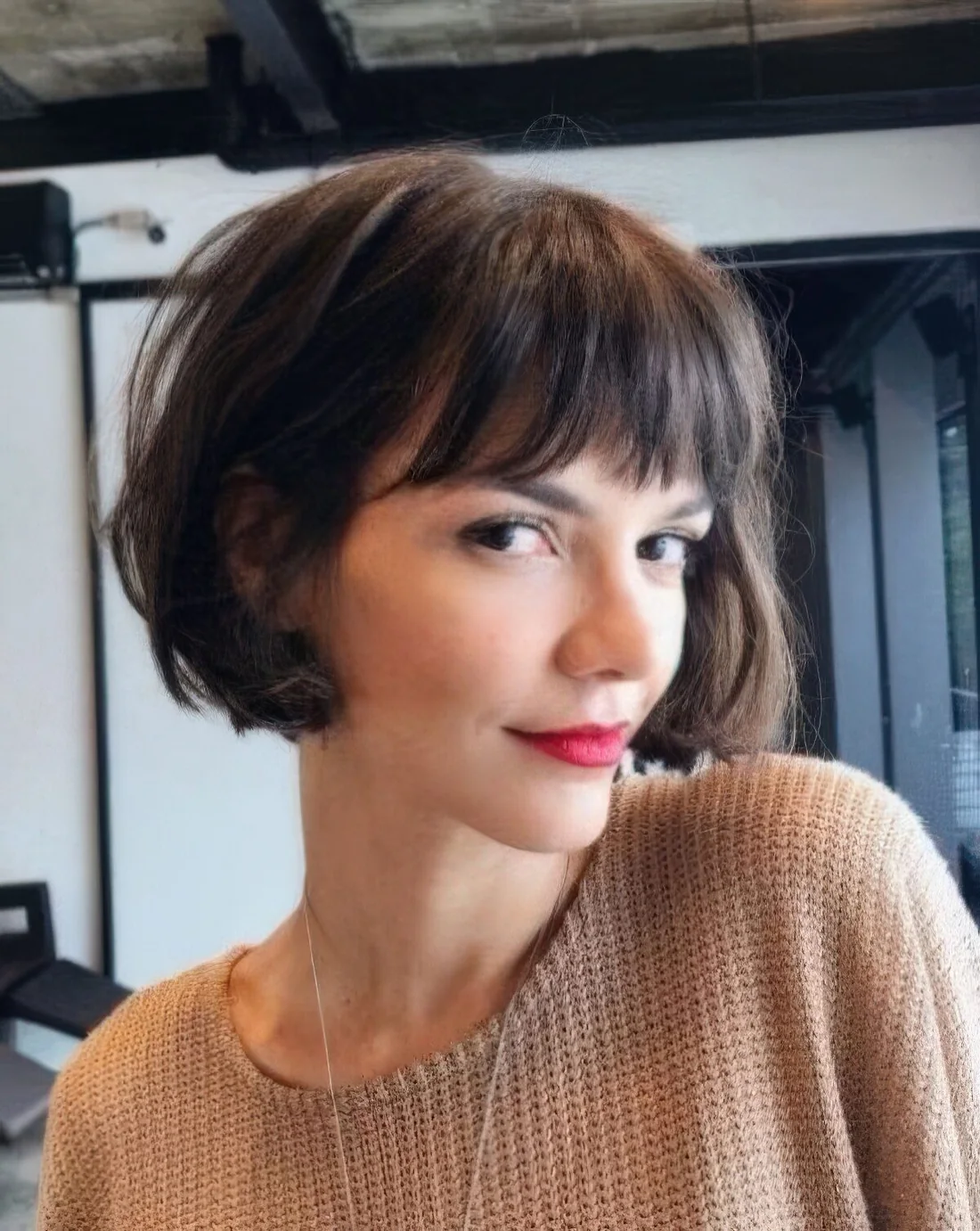 Brown French bob with bangs and waves.