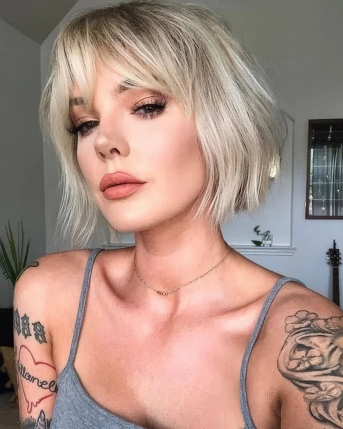 Blonde French bob with waves and bottleneck bangs.