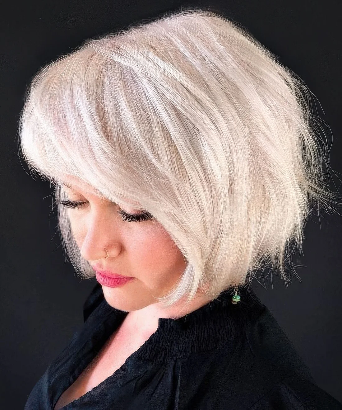 Platinum blonde feathered bob with side bangs.