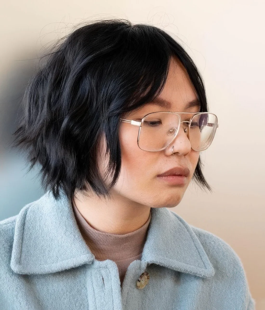 Graduated bob haircut in black, with curtain bangs.