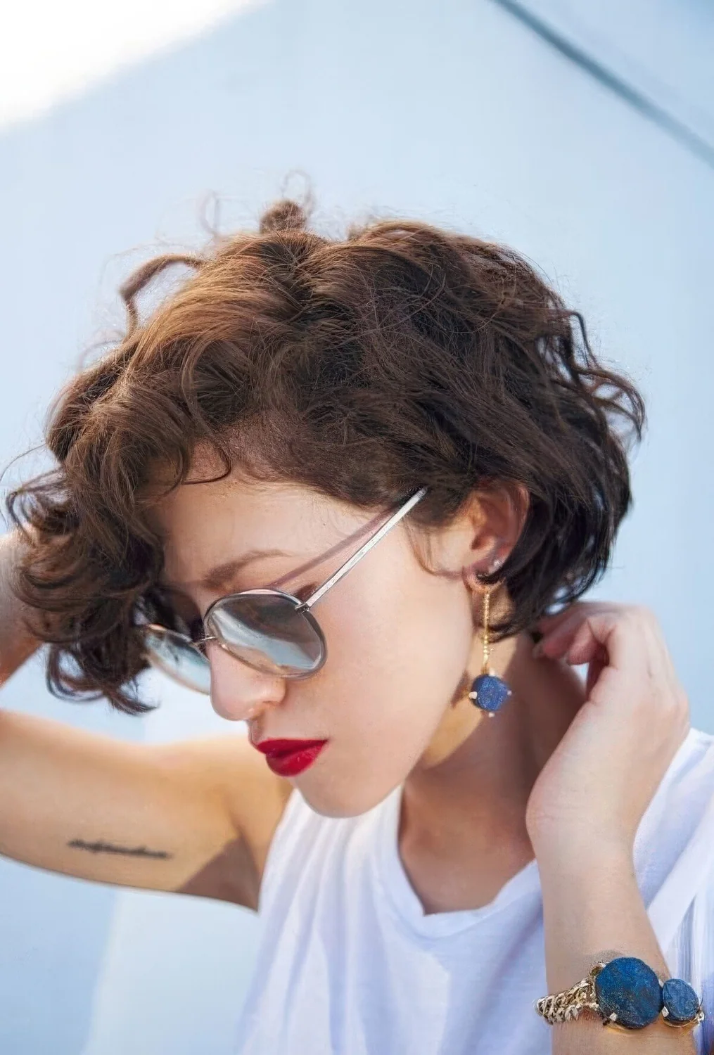Short brunette bob done on naturally wavy hair, with side part.