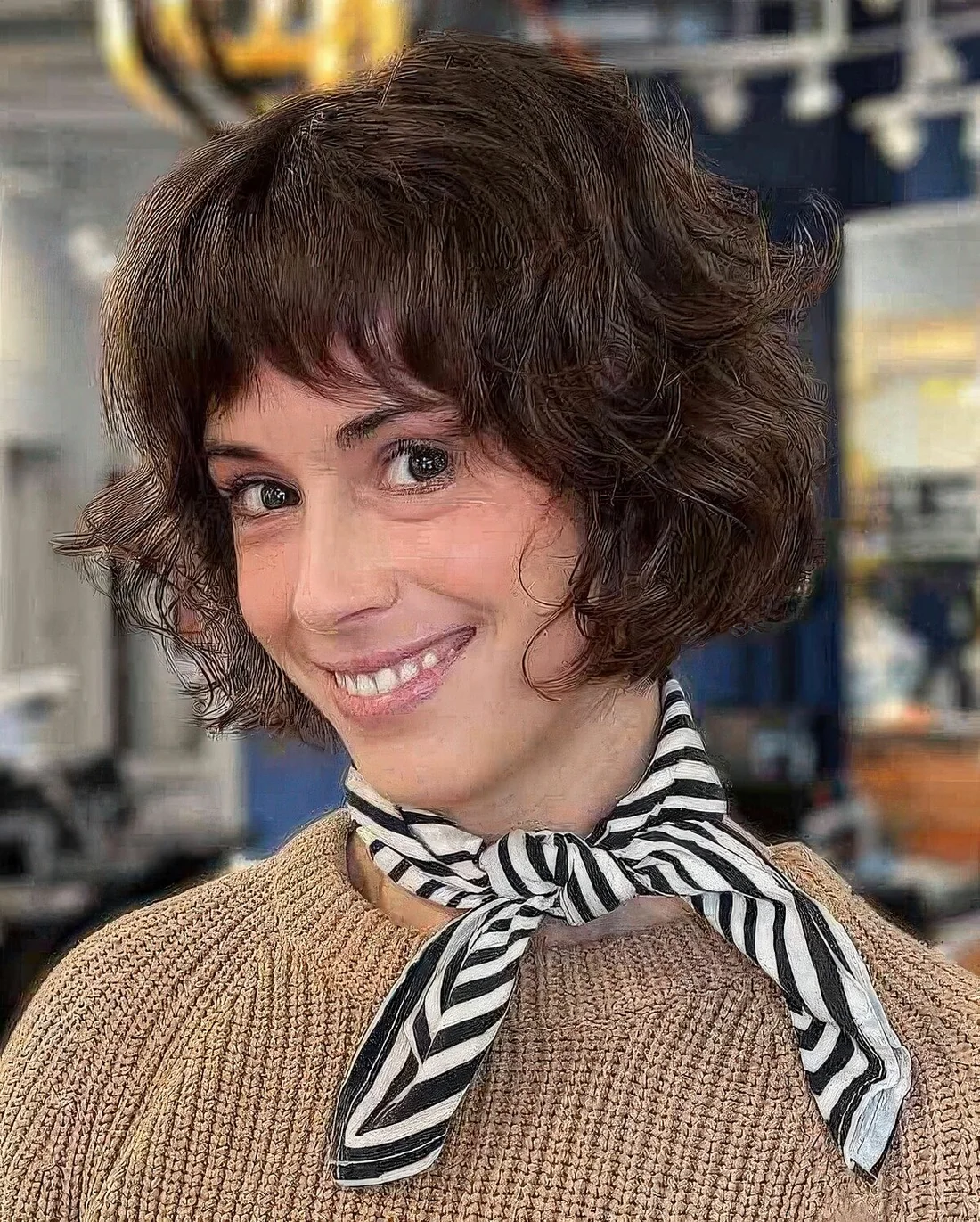 Short stacked French bob with feathered bangs and curls.