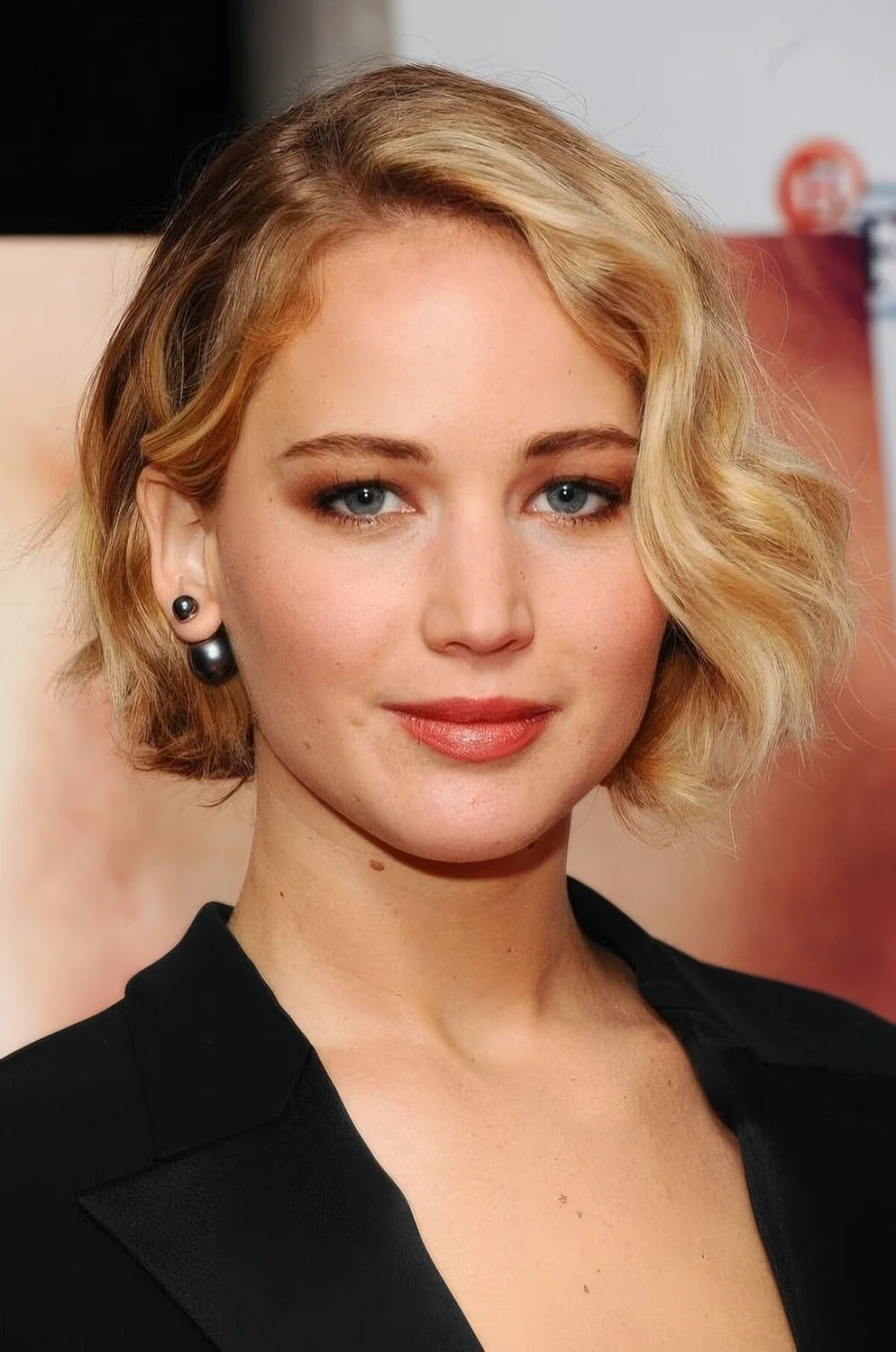 Wavy honey blonde jaw-length bob with side part.
