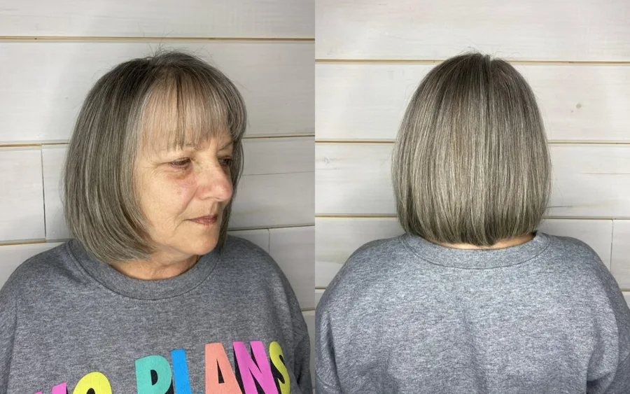 chin straight silver bob with blunt fringe shown as a layered bob hairstyles for older women idea