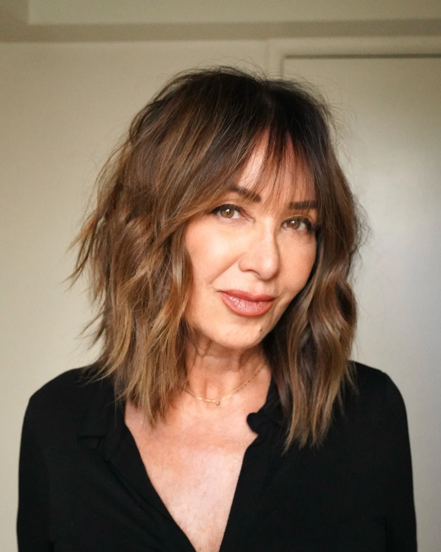 shoulder wavy brunette shag with curtain fringe shown as a layered bob hairstyles for older women idea