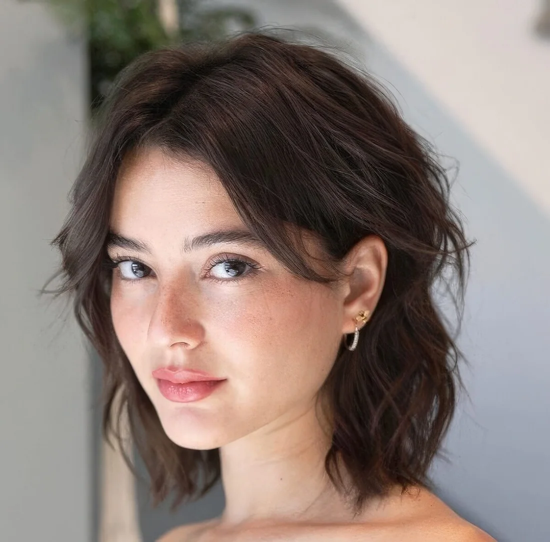 Dark softly layered bob with center part.