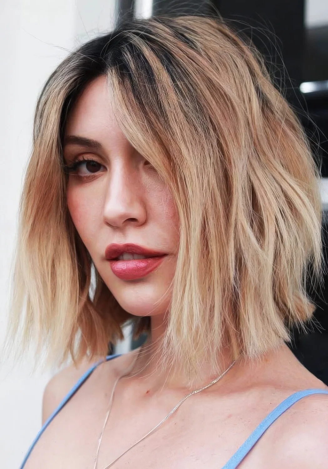 Center-parted layered long bob with a darker root and beautiful caramel and blonde balayage.