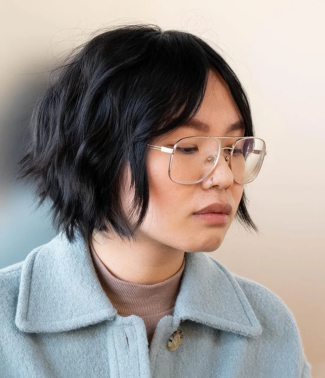 Graduated bob haircut in black, with curtain bangs.