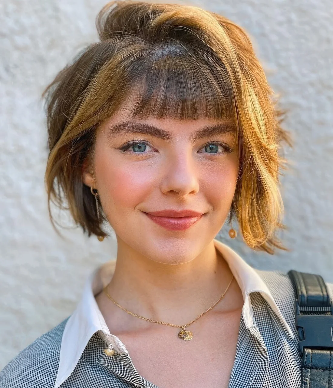 Layered bob with brighter locks and small, baby bangs.