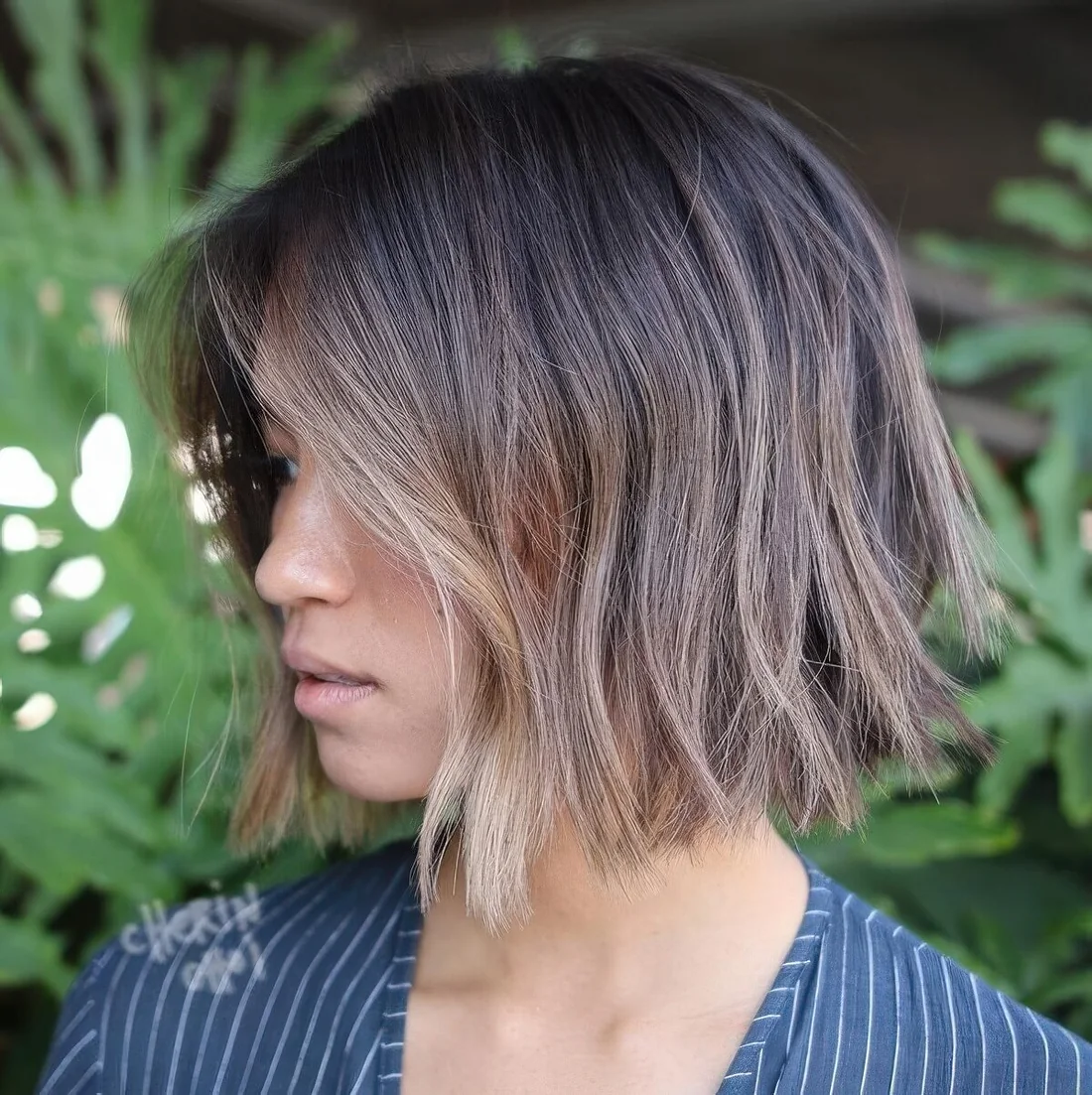Straight cut layered bob with a darker root and babylights.