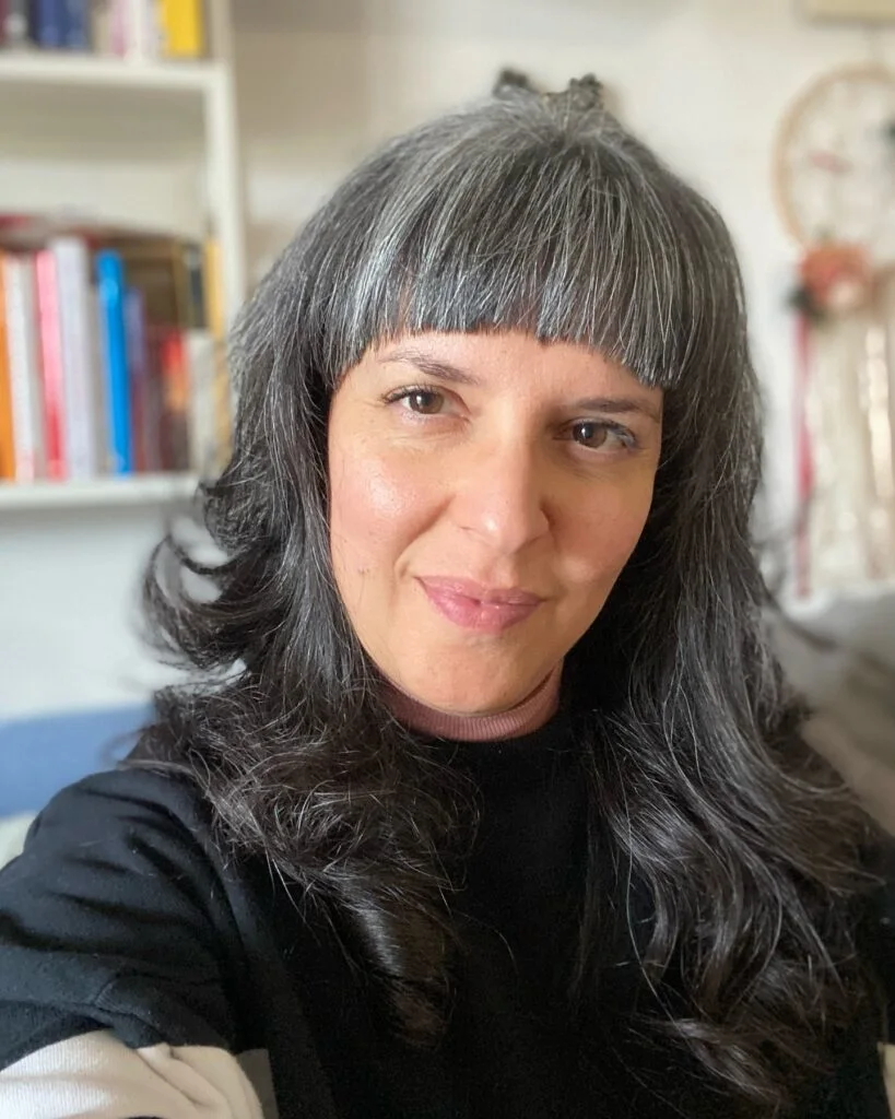 chest wavy gray layers with blunt fringe shown as a layered hair with bangs idea