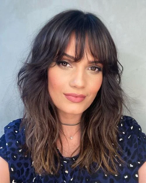 shoulder wavy brunette shag with wispy fringe shown as a layered hair with bangs idea