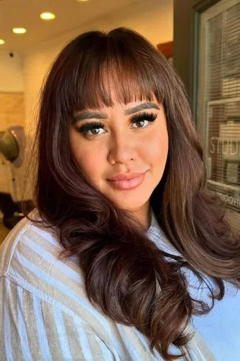 chest wavy brunette layers with blunt fringe shown as a layered hair with bangs idea