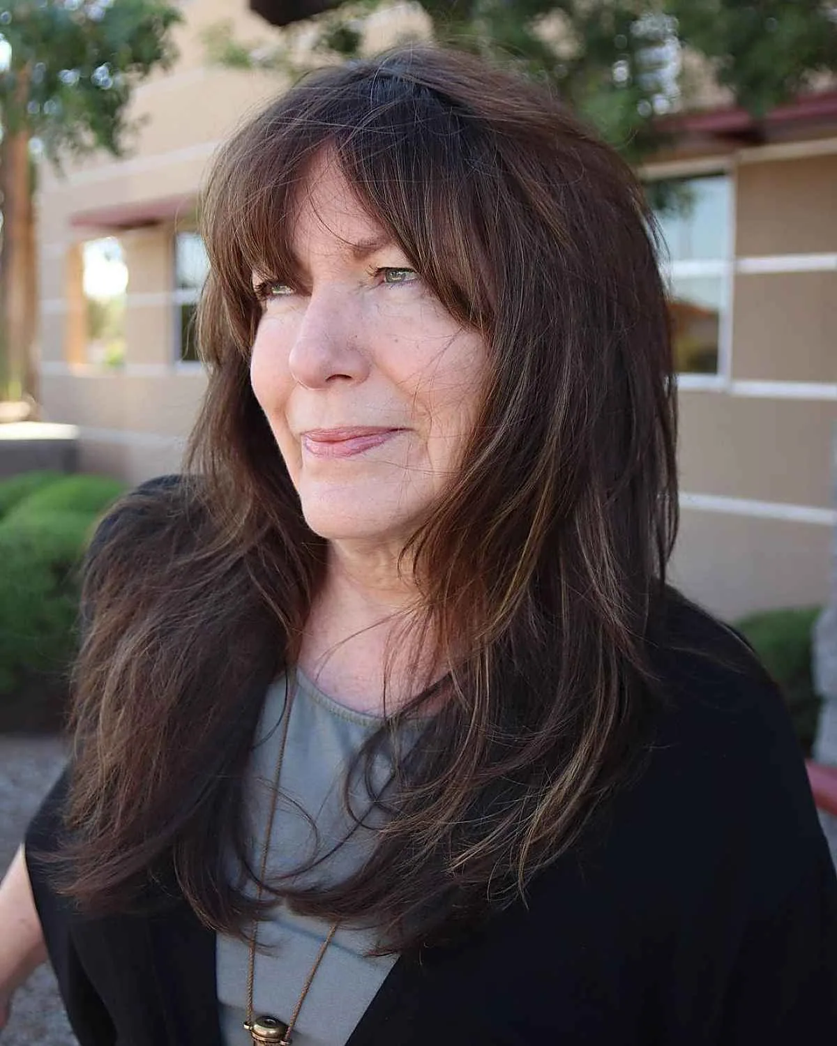 chest wavy brunette layers with curtain fringe shown as a layered hairstyles for women over 60 idea
